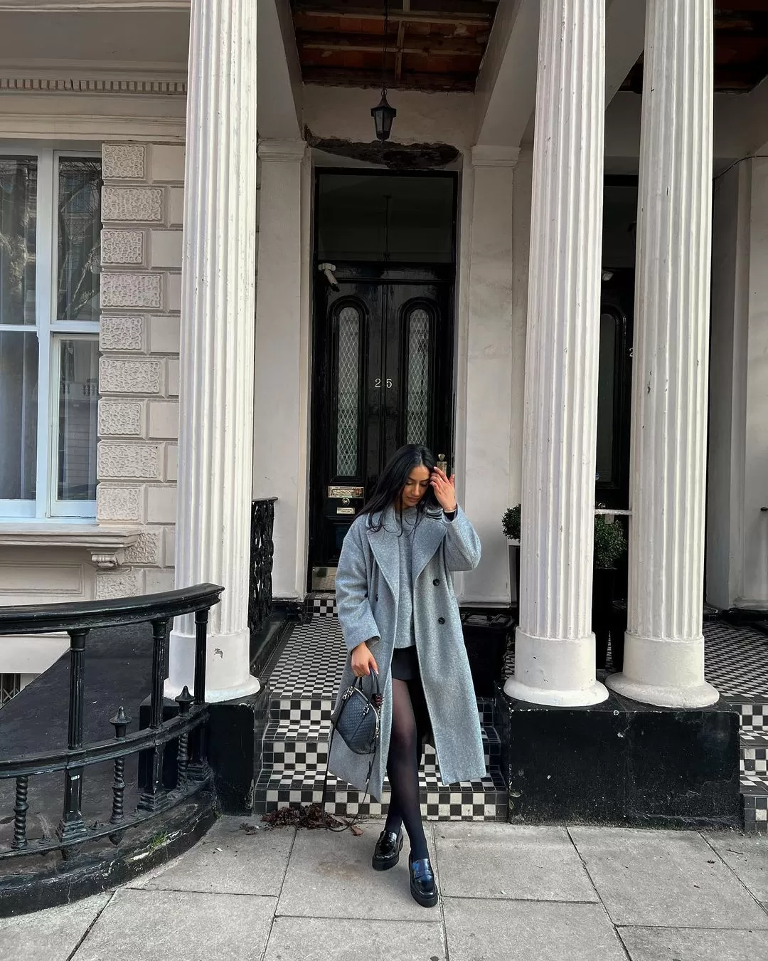 Long grey coat over a skort with a structured crossbody bag