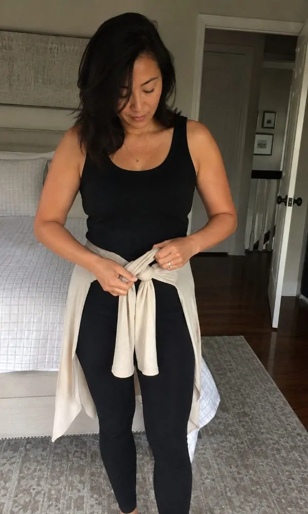Tying a lightweight cardigan around the waist for temperature control at the club