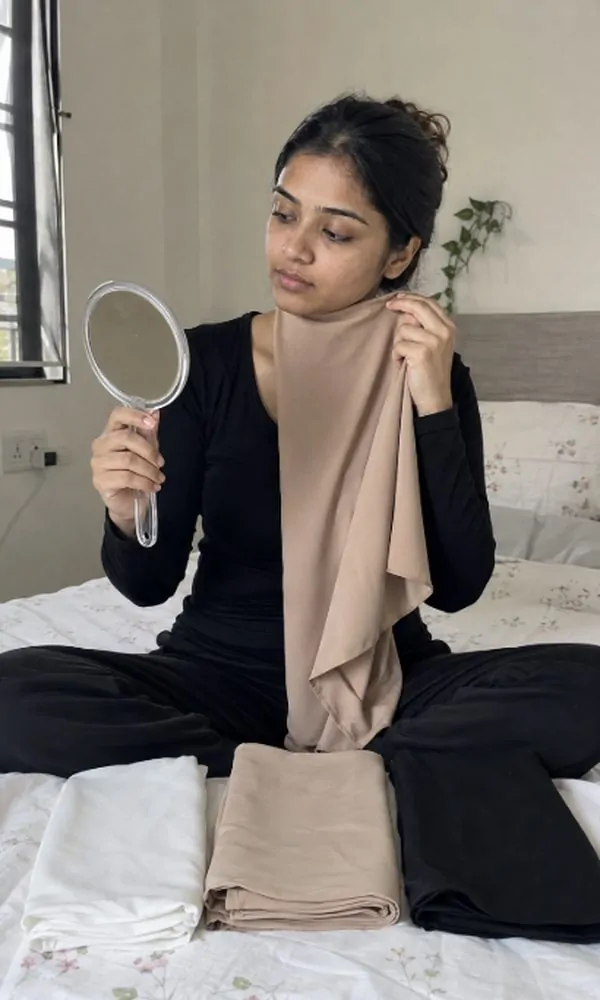 Woman choosing between white, nude, and black underscarf colors