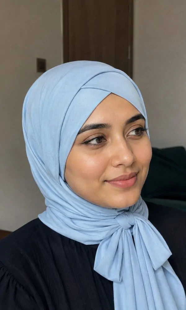Woman wearing a light blue crossover underscarf with tie detail