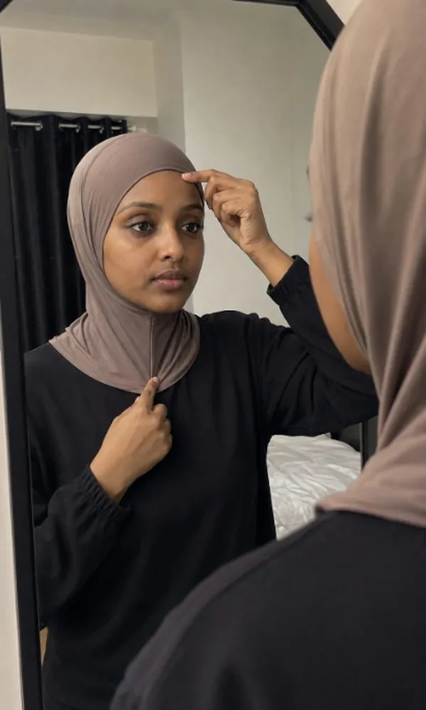 Woman checking underscarf hemline length against hairline