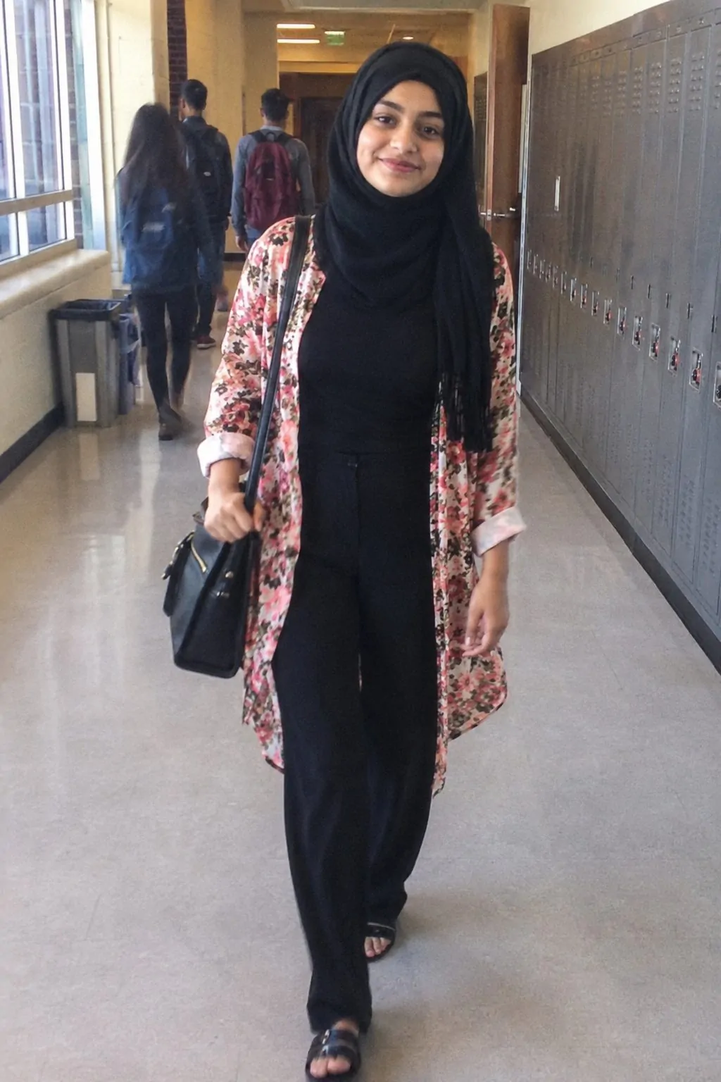 Hijabi student layering a floral kimono over a fitted black top for summer school