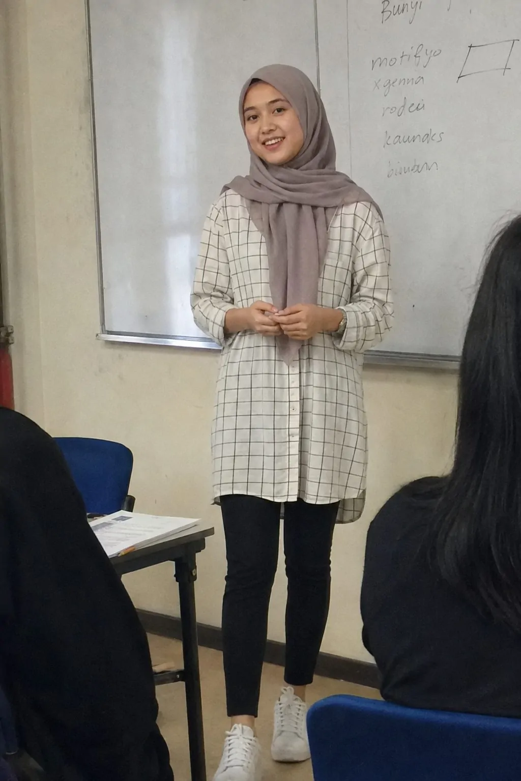 Hijabi student in an oversized grid-print shirt worn as a tunic over leggings