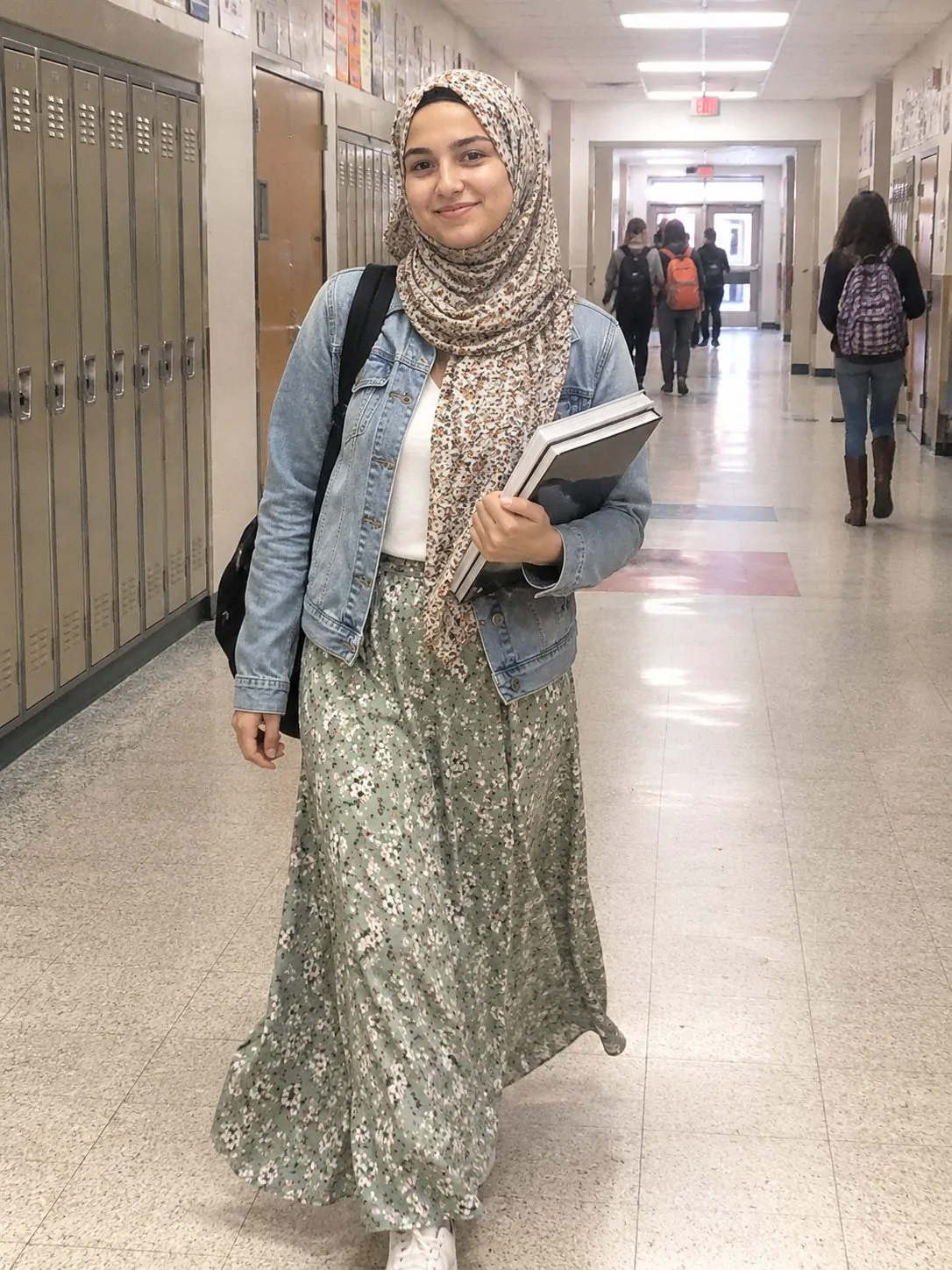 Hijabi girl mixing a sage green floral skirt with a denim jacket