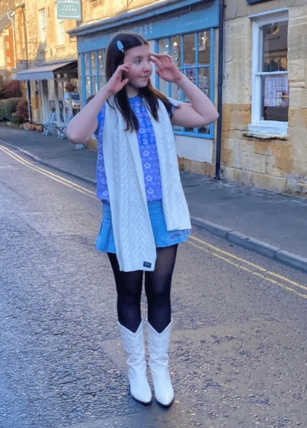 Wear A Blue Vest With A Denim Skirt And A White Wool Scarf