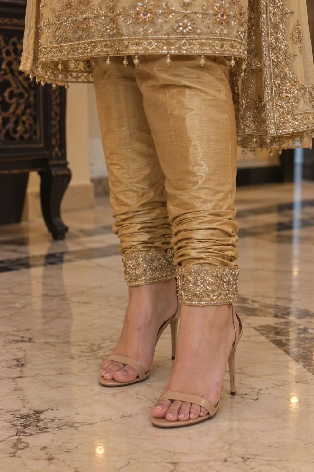 Golden chori dar with intricate ankle embroidery and nude heels